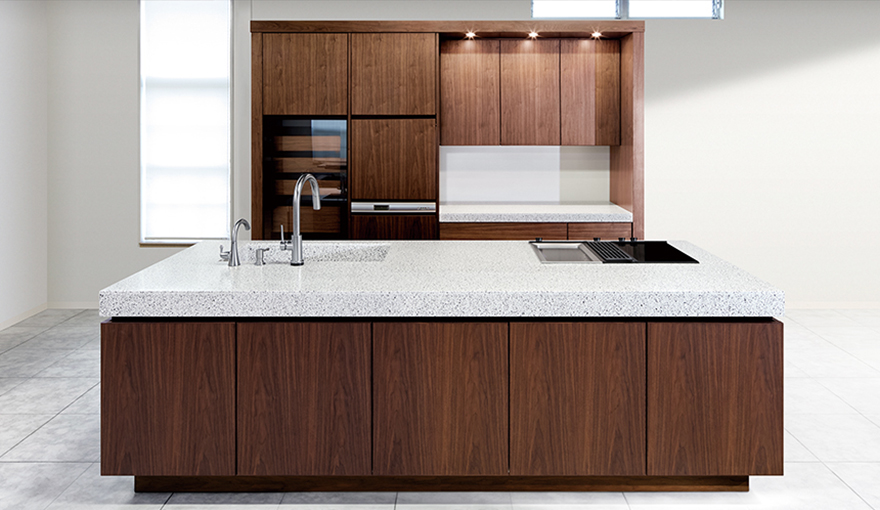 ワークトップからシンクの側面まで、同じホワイトテラゾーを使って一体に作られているため、シンクの存在感を感じない。機能を目立たないようにすることで、限りなく家具に近く、インテリアに馴染みやすいキッチンを提案している。（宮崎本社ショールーム）